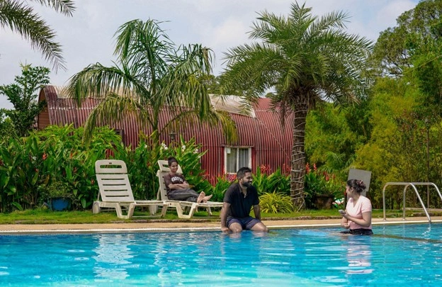 Couple enjoying a peaceful vacation at a Sakleshpur resort with
                            pool