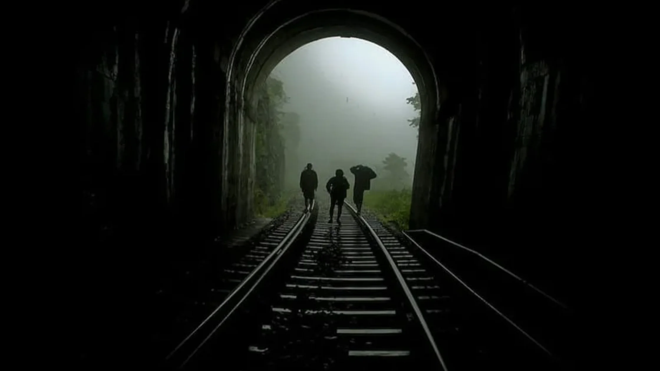 Trekkers walking through railway tunnel on Sakleshpur Green Route in monsoon